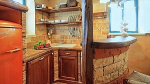 A kitchen with a stone countertop, wooden cabinets, and a built-in sink. - Vacation home Simone by Interhome (Dracevac)