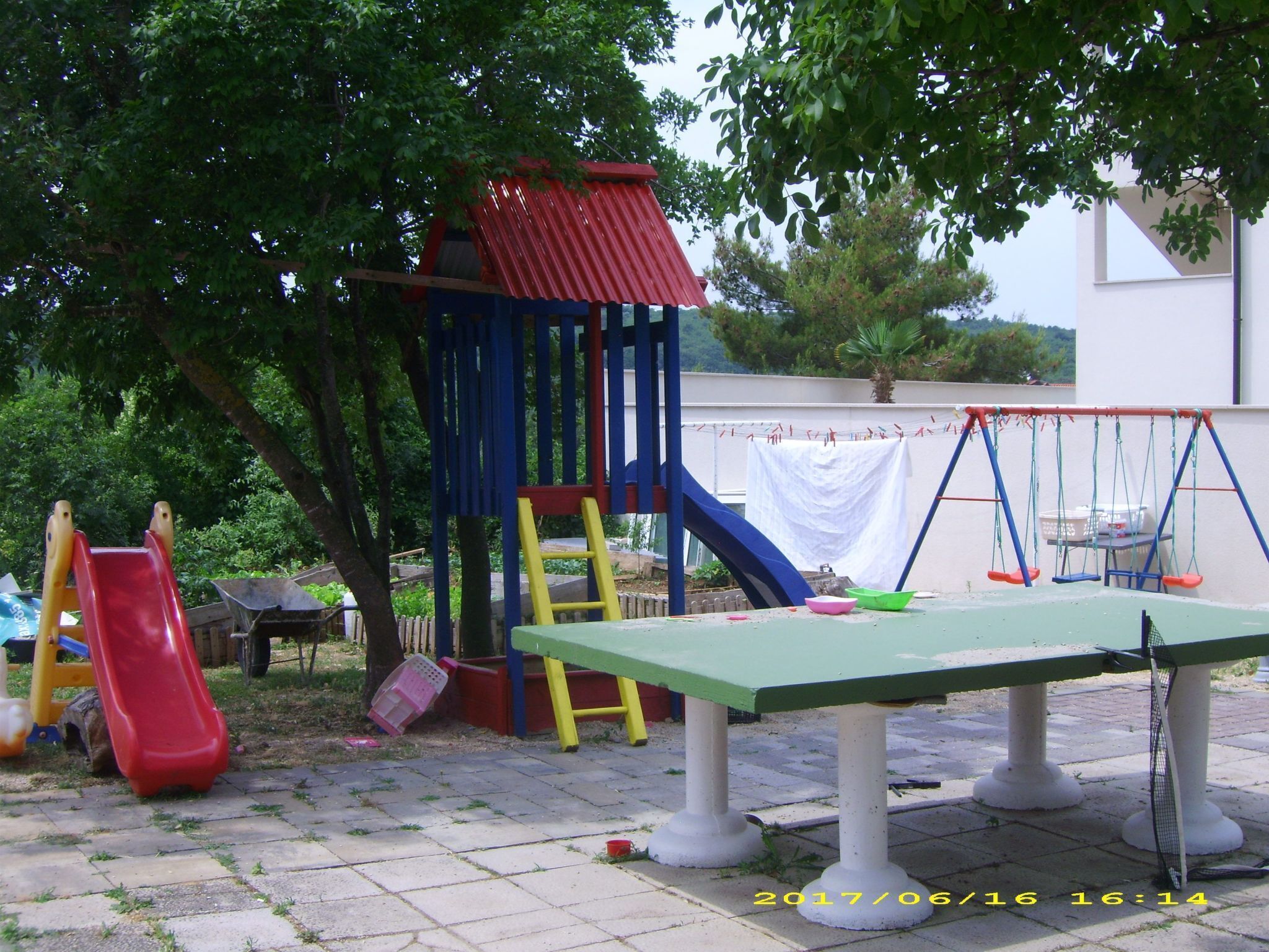 A playground with a slide, climbing structure, and swings.