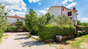 A residential area with a paved driveway leading to a house with a red-tiled roof. - Svoboda 2 by Interhome (Krk/Šilo)