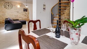 Un comedor con una mesa de madera, sillas y una botella de vino.