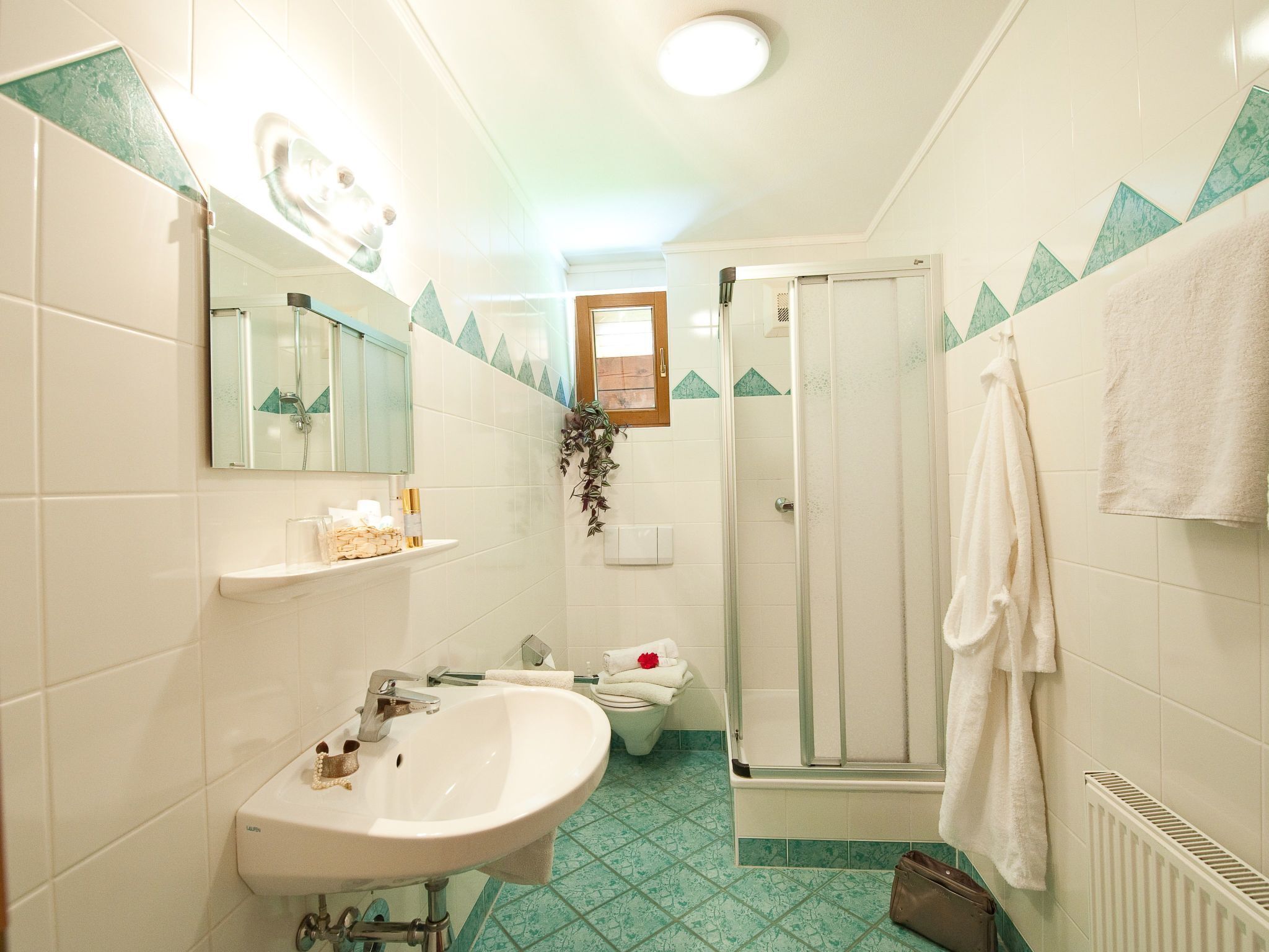 Un bagno con lavandino, specchio, doccia e WC.