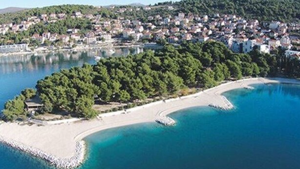 An aerial view of a coastal area with a beach, a small island with dense greenery, and a town in the background. - Wohnung mit Blick auf das Wasser by Interhome (Trogir)