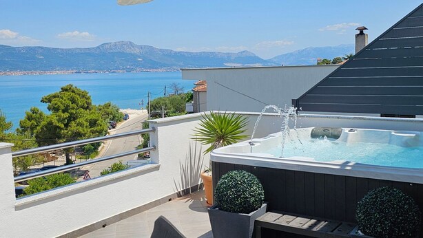 A balcony with a hot tub, potted plants, and a view of the sea and mountains. - "MaLea" mit Blick auf das Wasser by Interhome (Trogir)