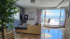 A modern living room with a sofa, a TV, and a balcony with a view. - "MaLea" mit Blick auf das Wasser by Interhome (Trogir)