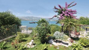 A garden with a white dog, a small pond, and a view of the sea with boats. - "MaLea" mit Blick auf das Wasser by Interhome (Trogir)