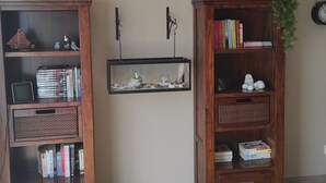 Deux étagères en bois, sur lesquelles on peut voir divers objets, notamment des livres, une maquette de bateau et une figurine d’oiseau.