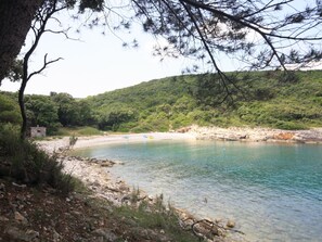A natural landscape with a clear lake, rocky shore, and a small building near the water's edge. - Villa Sole, Ferienvilla mit eigenem Pool bei Pul by Interhome (Divsici)