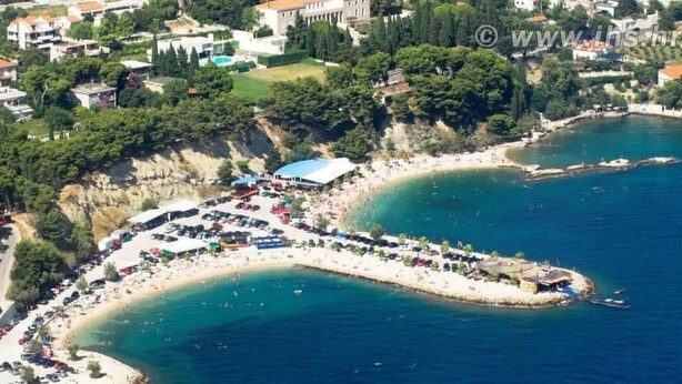 An aerial view of a coastal area with a curved beach, a parking lot, and buildings in the background. - Ruhige Ferienwohnung mit herrlicher Aussicht by Interhome (Dragovode)