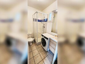 A bathroom with a toilet, a shower enclosure, a washing machine, and a sink. - mit Pool Villa Naiades by Interhome (Soulac)