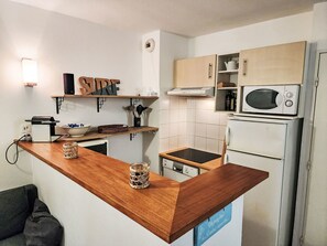 A compact kitchen with wooden countertops, a microwave, a built-in oven, and a small sink. - mit Pool Villa Naiades by Interhome (Soulac)