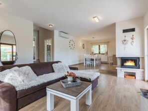 Ein modernes Wohnzimmer mit einem braunen Ledersofa, einem weißen Couchtisch und einem Kamin.