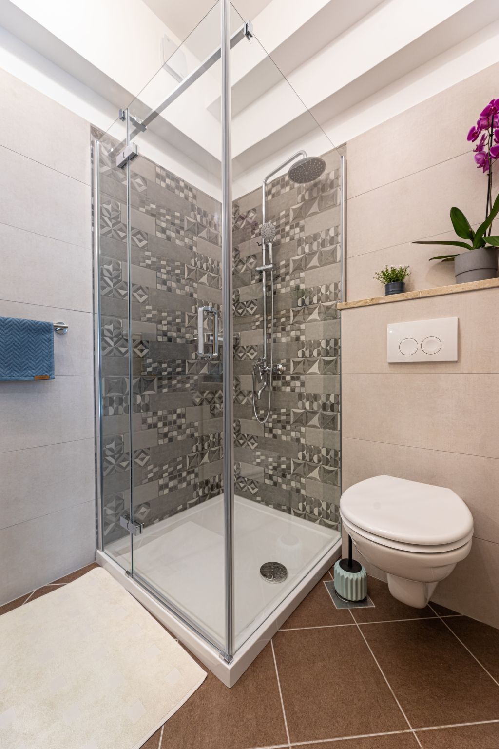 Een moderne badkamer met een douchecabine van glas, een toilet en een wastafel.
