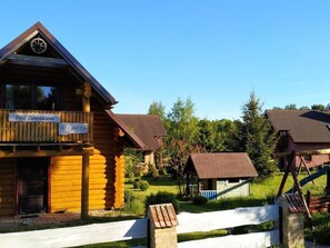 Un bâtiment en bois doté d’un balcon, d’une enseigne indiquant « Pod Sumakiem » et d’un numéro de téléphone.