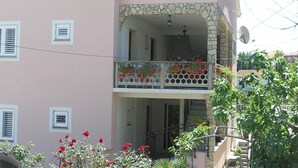 A two-story building with a balcony, stone facade, and a satellite dish. - Zwei-Zimmer-Wohnung Radosav by Interhome (Krk/Šilo)