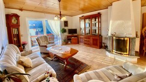 A living room with a sofa set, a coffee table, a fireplace, a television, and a cabinet. - Chalet Kristall by Interhome (Albinen)