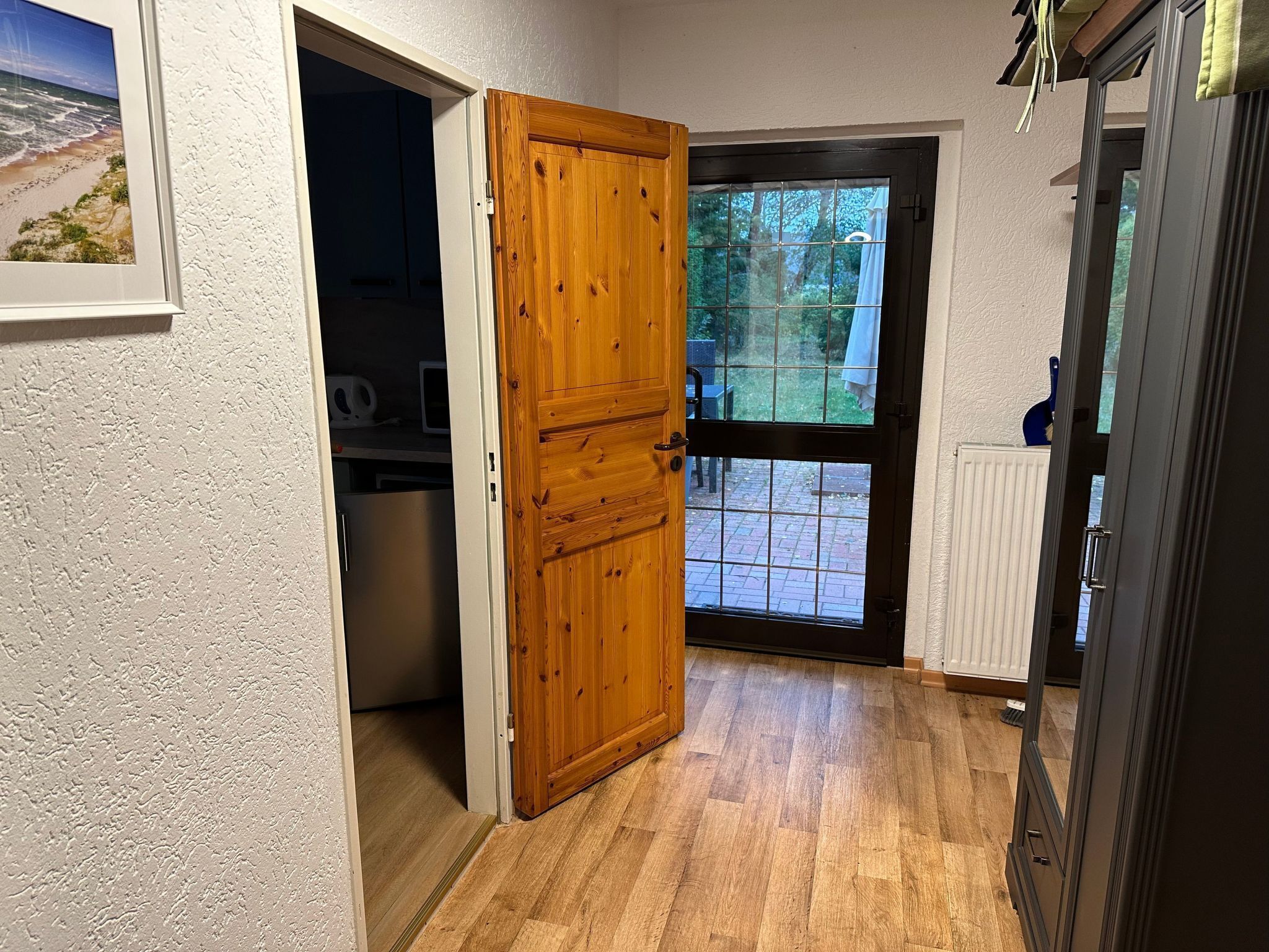 Un couloir avec une porte en bois donnant sur un patio.