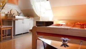 Ein kleines Schlafzimmer mit Bett, Schreibtisch und Stuhl.