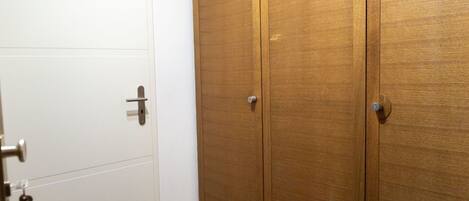 Una habitación con una puerta blanca y un armario de madera con dos puertas.