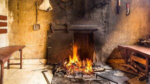 A rustic room with a fireplace, wooden benches, and a brick wall. - Carpe Diem by Interhome (Trogir)