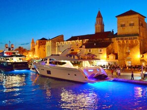 Eine große Yacht liegt in einer Marina vor einer historischen Gebäude.