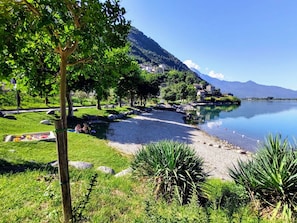 Ein Park am Seeufer mit Kiesweg, Bänken und einer Picknickgegend.