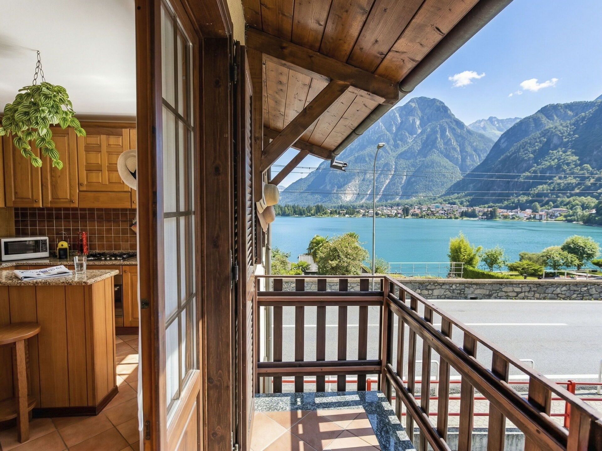 Ein Holzinnenraum mit einer Küche, einem Balkon mit Seeblick und Bergblick.