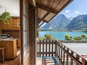 Ein Holzinnenraum mit einer Küche, einem Balkon mit Seeblick und Bergblick.