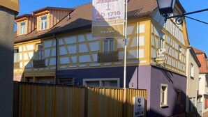 Um edifício tradicional em estilo de enxaimel com uma placa anunciando apartamentos.