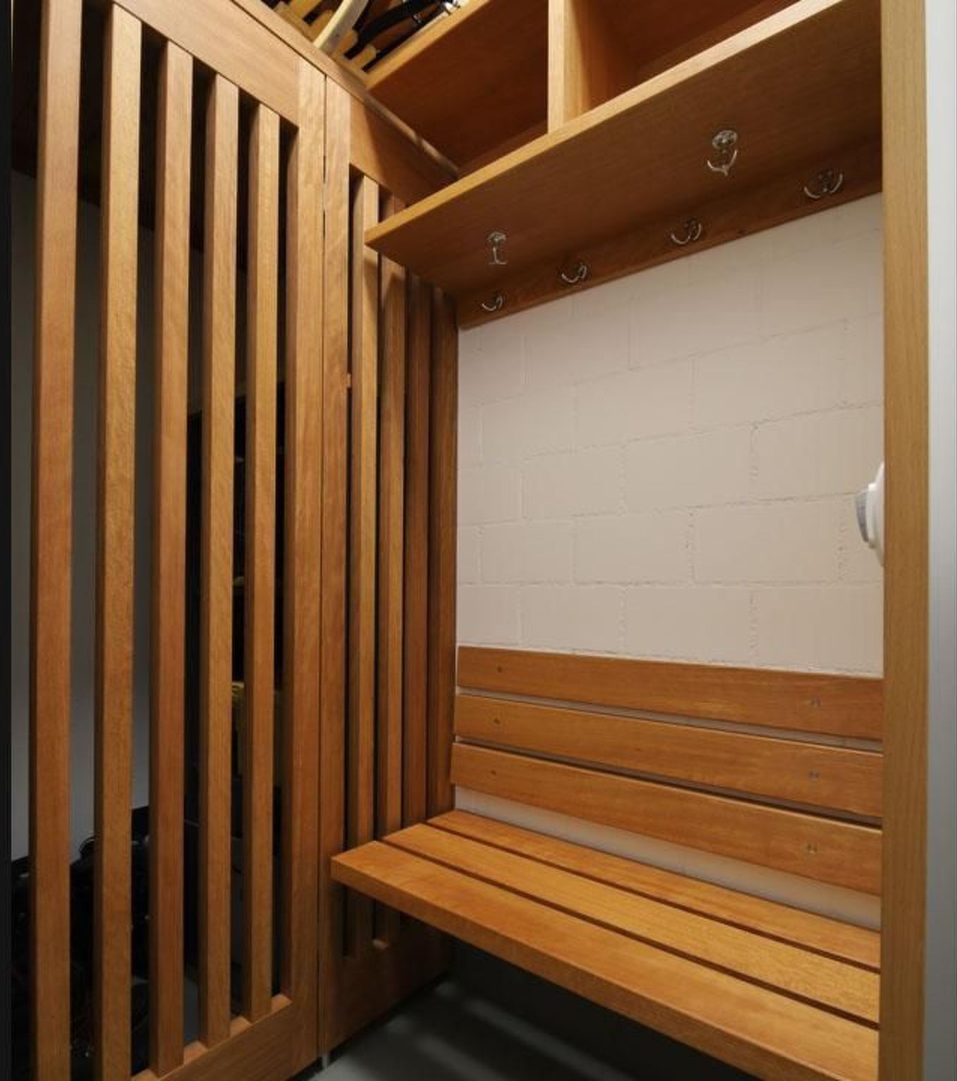 A wooden bench with a white brick wall in the background.