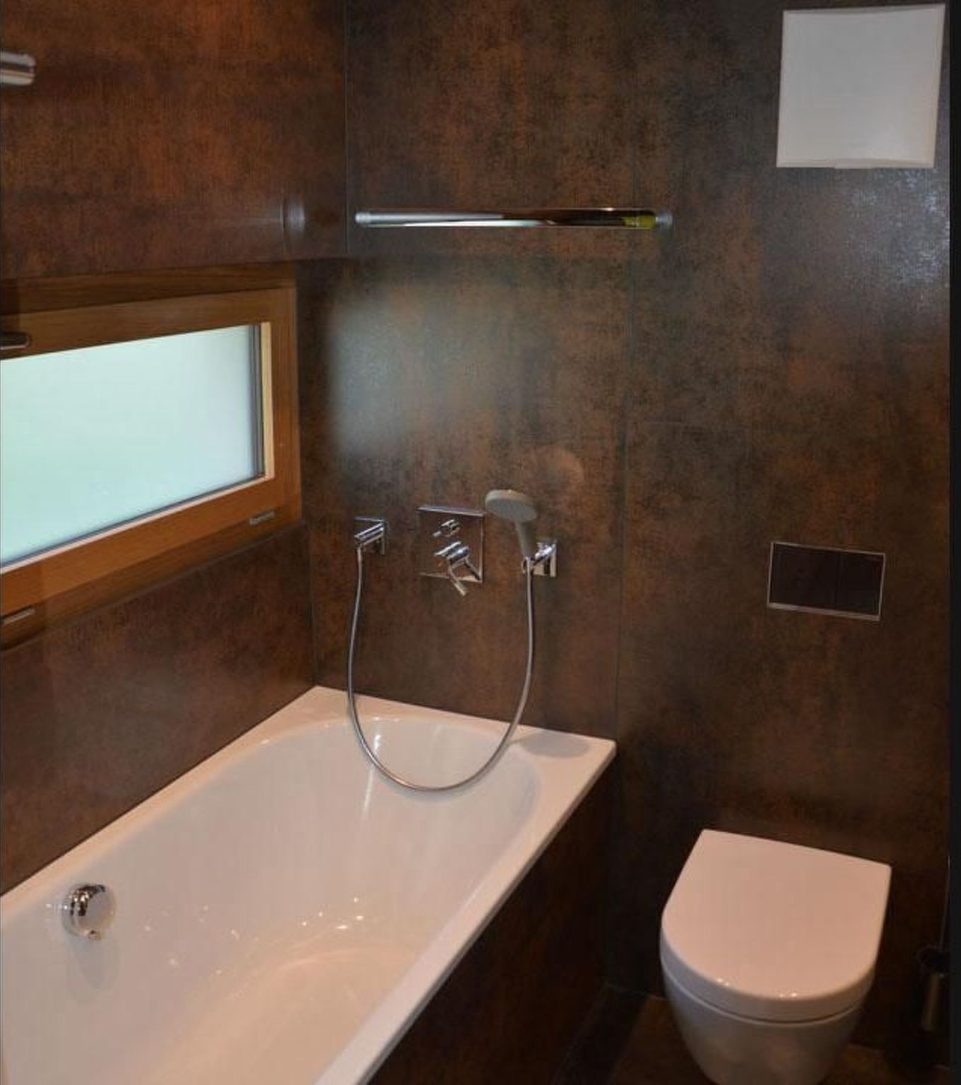 A bathroom with a bathtub, a toilet, and a window.