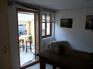 A room with a wooden table, a chair, a small potted plant, and a window with blinds. - Wohnung in Linz Am Rhein by Interhome (Linz,)