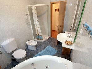 Ein Badezimmer mit Badewanne, Waschbecken, Toilette und Duschbereich.