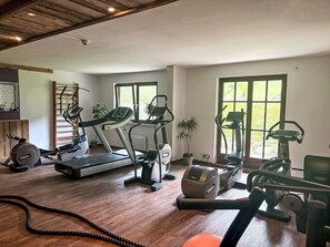 A home gym with various exercise equipment including a treadmill, elliptical, and stationary bike. - Apartment Daniel by Interhome (Gosau)
