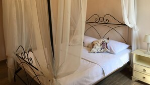 Un lit à baldaquin, une table de chevet et une lampe.