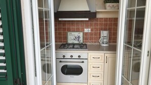 A compact kitchen with a gas stove, oven, and a coffee maker. - Appartement in Stoja mit Möbliertem Balkon by Interhome (Pula)