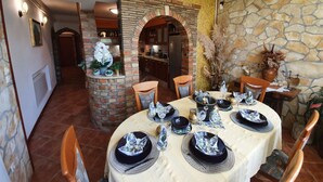 A dining area with a round table set for four, surrounded by stone walls and a brick archway. - Wohnung 'Ivaana' mit Privatparkplatz by Interhome (Rovinj)