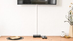 A wooden TV stand with a flat-screen TV mounted on the wall above it. - Siebers by Interhome (Altendorf)
