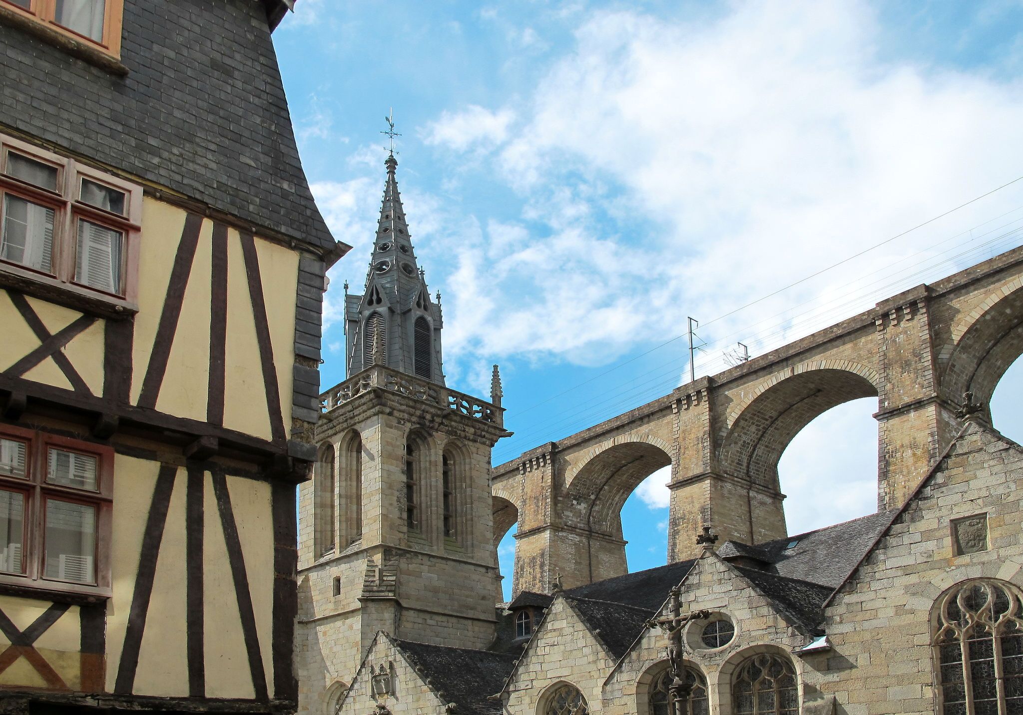 A historic building with a prominent tower and arched bridge structure.