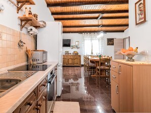 A kitchen with a stove, microwave, and wooden cabinets. - Haus Plum by Interhome (Drenje)