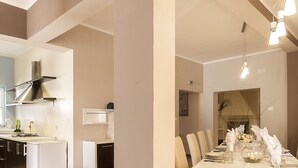 Una cocina moderna con estufa integrada, campana extractora de acero inoxidable y refrigerador blanco.