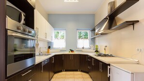 Una cocina moderna con armarios de madera oscura, electrodomésticos de acero inoxidable y una isla central.
