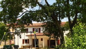 A two-story building with a tiled roof, a swing set, and a bench in the yard. - Istrien Haus neunte Pina by Interhome (Poreč/Kaštelir)