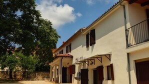 A row of white buildings with red-tiled roofs, wooden shutters, and a gravel pathway. - Istrien Haus neunte Pina by Interhome (Poreč/Kaštelir)