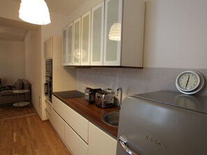A modern kitchen with white cabinets, a stainless steel Bosch refrigerator, a sink, and a toaster. - Moderne Stadtwohnung by Interhome (Vienna)