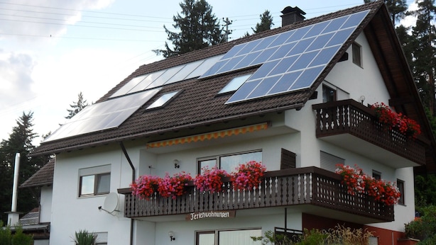 A two-story house with solar panels on the roof, a balcony with red flowers, and a sign that reads "Ferienwohnungen". - Apartment Gaby by Interhome (Bonndorf)