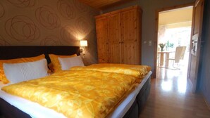 Un dormitorio con una cama grande, un armario de madera y vistas a un comedor.