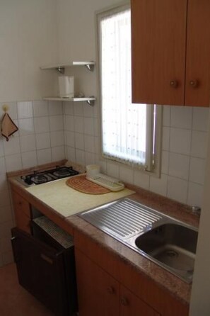 Een koelkast, kookgerei, borden en bestek