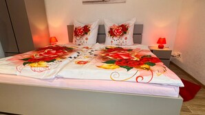 Um quarto com uma cama grande, duas mesas de cabeceira e uma mesinha de apoio.