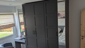 Ein Schlafzimmer mit großem Kleiderschrank, Schreibtisch und Stuhl.