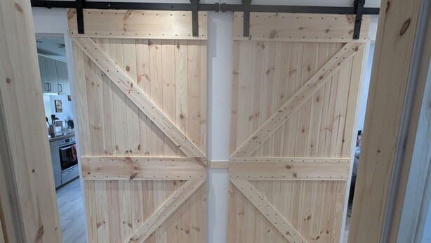 Eine Holztür im Scheunenstil, schlicht und modern gestaltet.